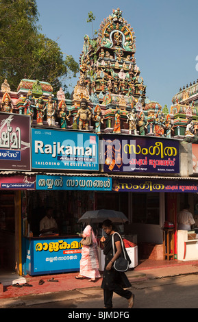 India, Kerala, Alappuzha, (Alleppey), YMCA Road, shops below colourful small Hindu Temple Stock Photo