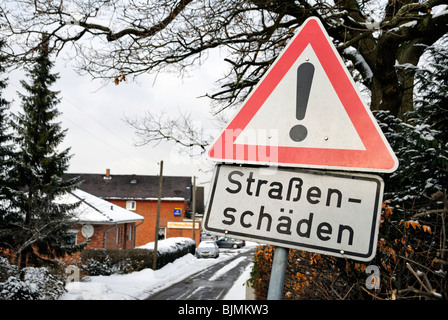 Hard winter, traffic sign 'Strassenschaeden' road damage Stock Photo