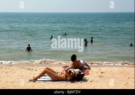 India, Kerala, Vypeen Island, Cherai Beach western sunbathers relaxing on sand Stock Photo