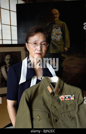 uko Tojo, granddaughter of Japan's wartime leader, Gen. Hideki Tojo, poses with her grandfather's uniform at her home in Tokyo Stock Photo