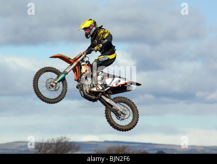 Motorcyclist flying high in the air on his motocross bike. Stock Photo