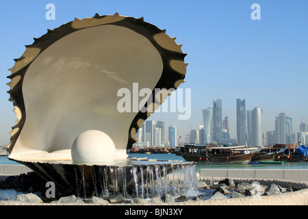 The oyster and pearl fountain on the Corniche in central Doha, Qatar, with the Dhow harbour and the new skyline beyond. Stock Photo