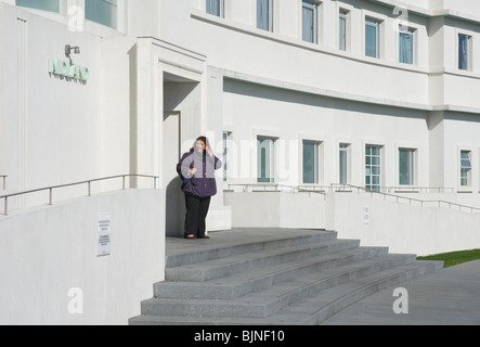 Woman on steps of the art deco Midland Hotel, Morecambe, Lancashire, England UK Stock Photo