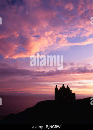 On sea cliffs Dunskey Castle silhouetted against the sunset looking up the North Channel to Ireland near Portpatrick Galloway UK Stock Photo