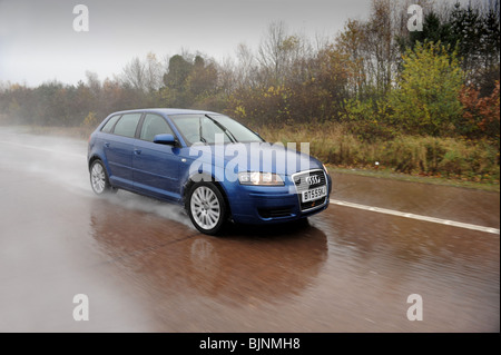 Audi A3 car in heavy rain on motorway uk Stock Photo
