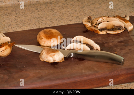 Chopping small portobello mushrooms Stock Photo