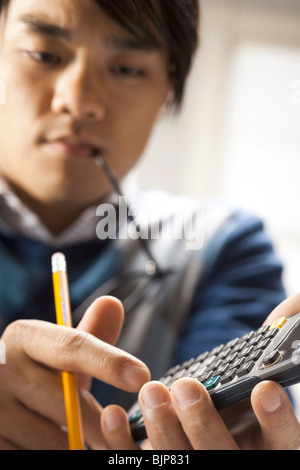Students looking at a calculator Stock Photo - Alamy