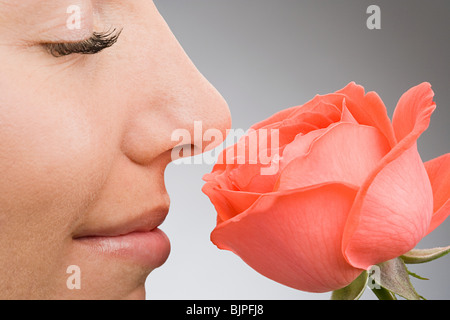 Rose for a rose. Profile of a young woman smelling a pink rose Stock ...