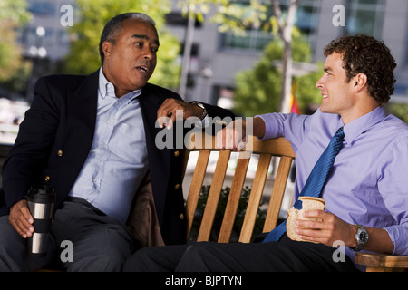 Businessmen on park bench Stock Photo