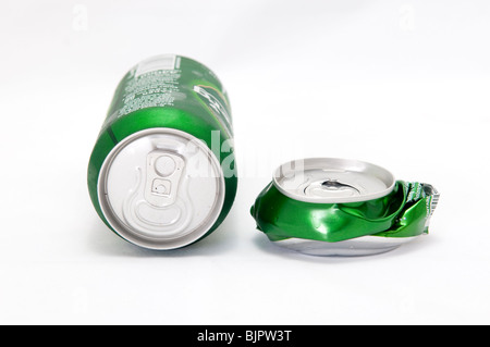 Beer can laying next to crushed beer can Stock Photo