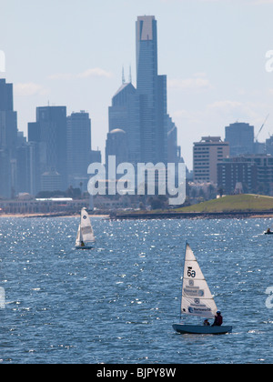 TWO DINGHIES SAILING ON PORT PHILLIP BAY WITH SKYLINE OF MELBOURNE ON HORIZON Stock Photo