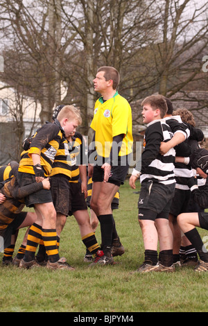 Junior Under 12s rugby game match referee instructs the young players to scrum Stock Photo