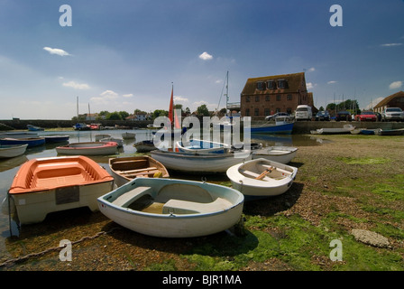 Emsworth harbour with dingies sitting on the shore surrounded by seaweed at low tide with the slipper sailing club Stock Photo