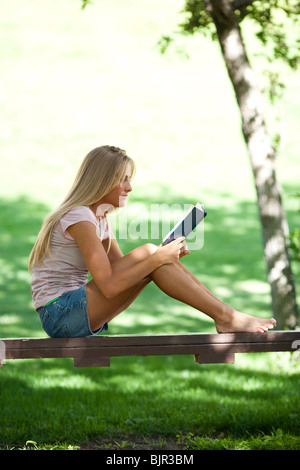 Teenage girl reading outside Stock Photo