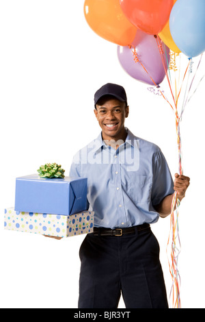 Deliveryman holding gifts and balloons Stock Photo
