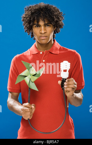 young man with pinwheel and energy saving light bulb Stock Photo