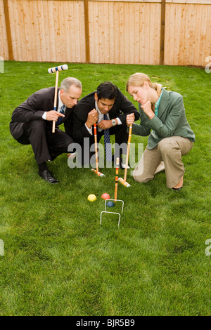 Three businesspeople playing croquet Stock Photo