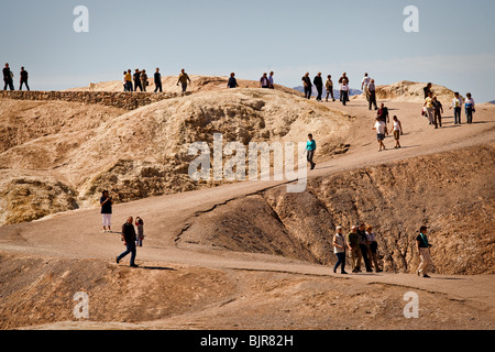 Tourists at the scenic overlook at the badlands at Zabriskie Point looking toward Golden Canyon in Death Valley National Park Stock Photo