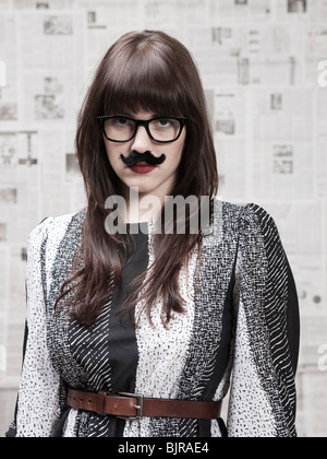 Studio portrait of young woman wearing fake moustache Stock Photo