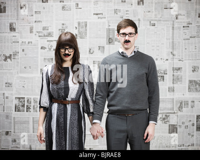 Studio portrait of young couple wearing fake moustaches Stock Photo