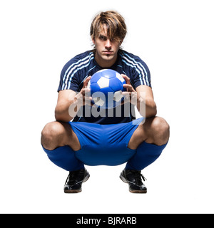 Studio portrait of soccer player holding ball Stock Photo