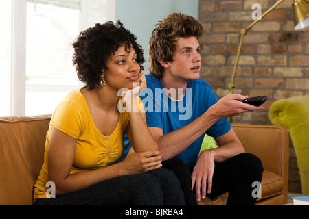 USA, Utah, Provo, young couple watching television in living room