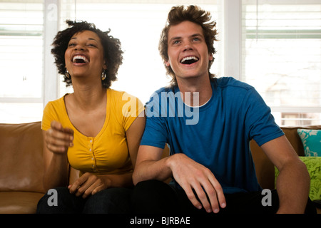 USA, Utah, Provo, young couple watching television in living room