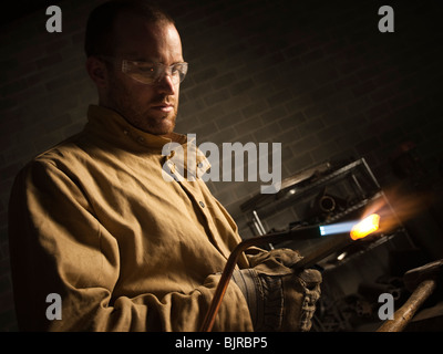 USA, Utah, Orem, male welder using blowtorch in workshop Stock Photo