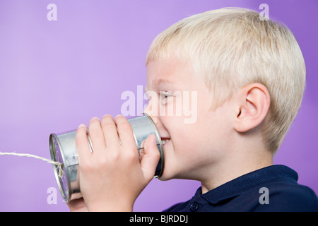 Boy talking on a tin can telephone Stock Photo