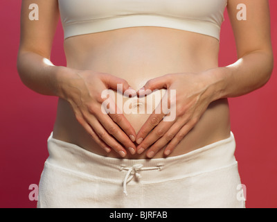 Pregnant woman with heart shape on stomach Stock Photo