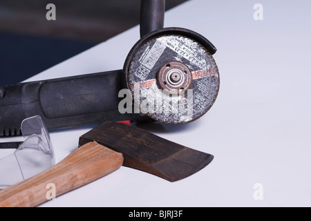 An angle grinder, axe and safety goggles. Stock Photo