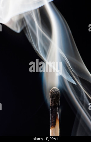 Smoking match against black background Stock Photo