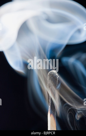 Smoking match against black background Stock Photo