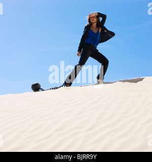 USA, Utah, Little Sahara, businesswoman wearing ball and chain in desert Stock Photo