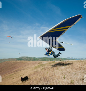 USA, Utah, Lehi, young man taking off with hang glider Stock Photo