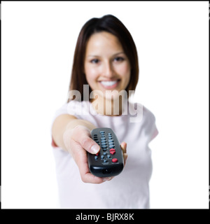 Woman pointing and pressing a handheld remote control Stock Photo