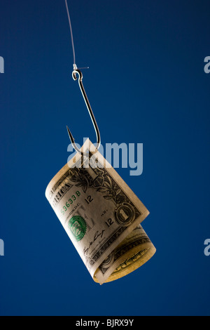 One US dollar bill on hook, against blue background Stock Photo