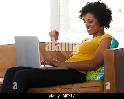 USA, Utah, Provo, young woman sitting on sofa and using laptop Stock Photo