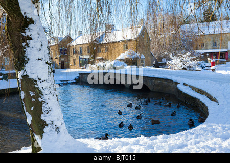 Winter snow on one of the bridges over the River Windrush in the Cotswold village of Bourton on the Water, Gloucestershire Stock Photo