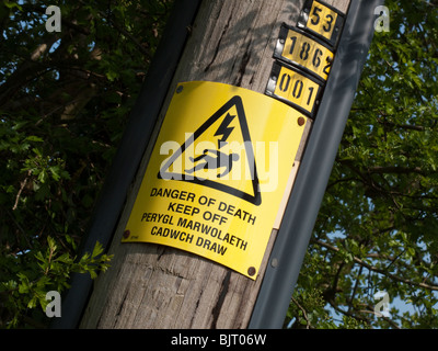 DANGER OF DEATH SIGN SIGN ON POWER CABLE POLE IN ENGLISH AND WELSH Stock Photo