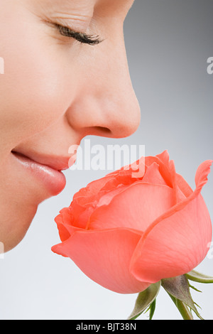 Rose for a rose. Profile of a young woman smelling a pink rose Stock ...