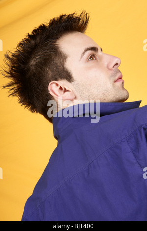 Portrait of a young man with blue shirt over a yellow background Stock Photo
