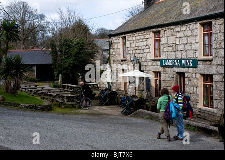 Holidaymakers visitors tourists waiting outside the Lamorna Wink public house in Cornwall. Stock Photo