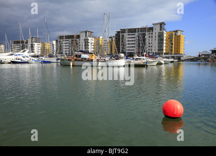 Boats moored in front of the modern apartments at South Harbour, Sovereign Harbour Marina, Eastbourne, East Sussex. Stock Photo