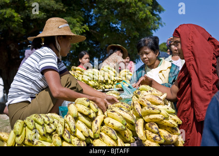 Buddhist monk buying bananas. Pakokku market. Myanmar Stock Photo