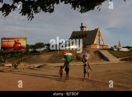 Woman carry children and food to sell on their heads in the town of Sumbe. Kwanza Sol, Angola, Africa Stock Photo