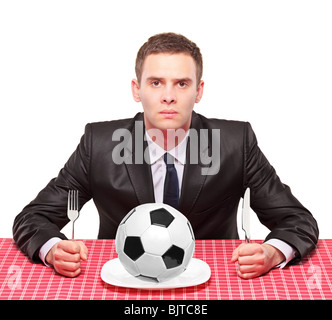 A businessman sited on a table with a ball in his plate Stock Photo