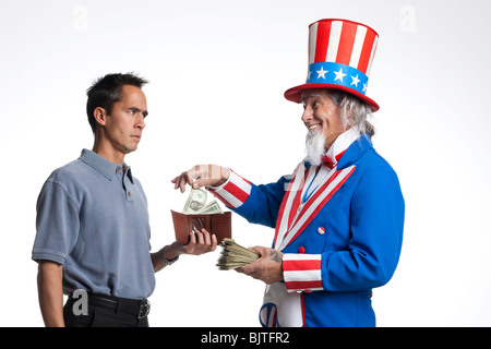 Man in Uncle Sam's costume taking money from other man, studio shot Stock Photo