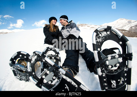 Couple resting with snow shoes Stock Photo