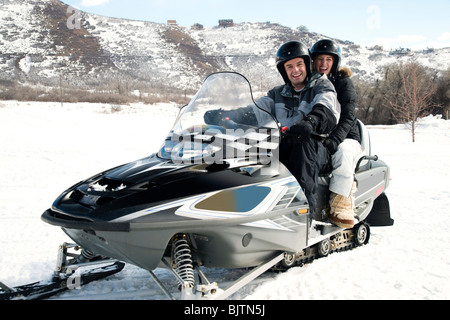 Couple on snow mobile Stock Photo